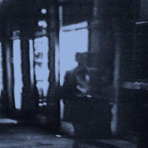 Fuzzy black and white picture of man in a hallway.