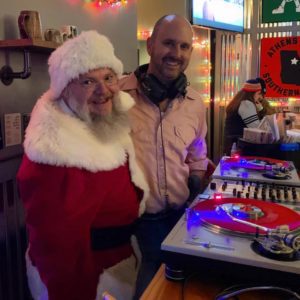 Picture of a DJ with Santa.
