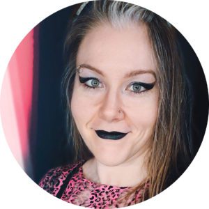 Picture of a woman with winged eyeliner and black lips.