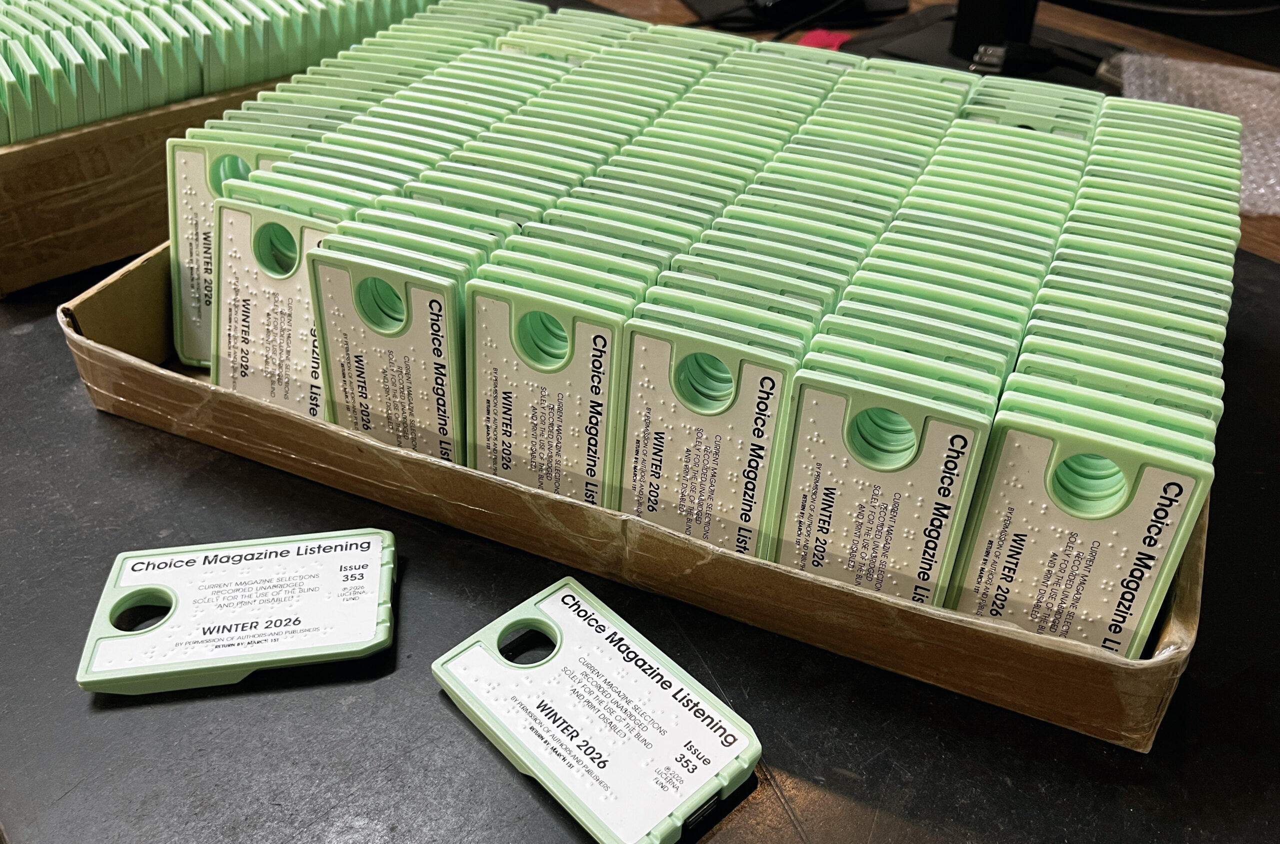 Choice Magazine digital cartridges with braille stacked in a tray