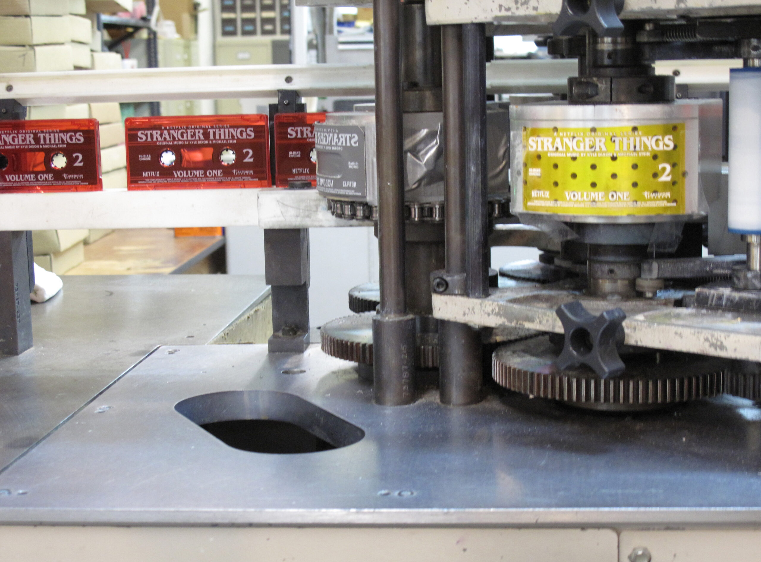 a cassette imprinting machine with Stranger Things cassette tapes